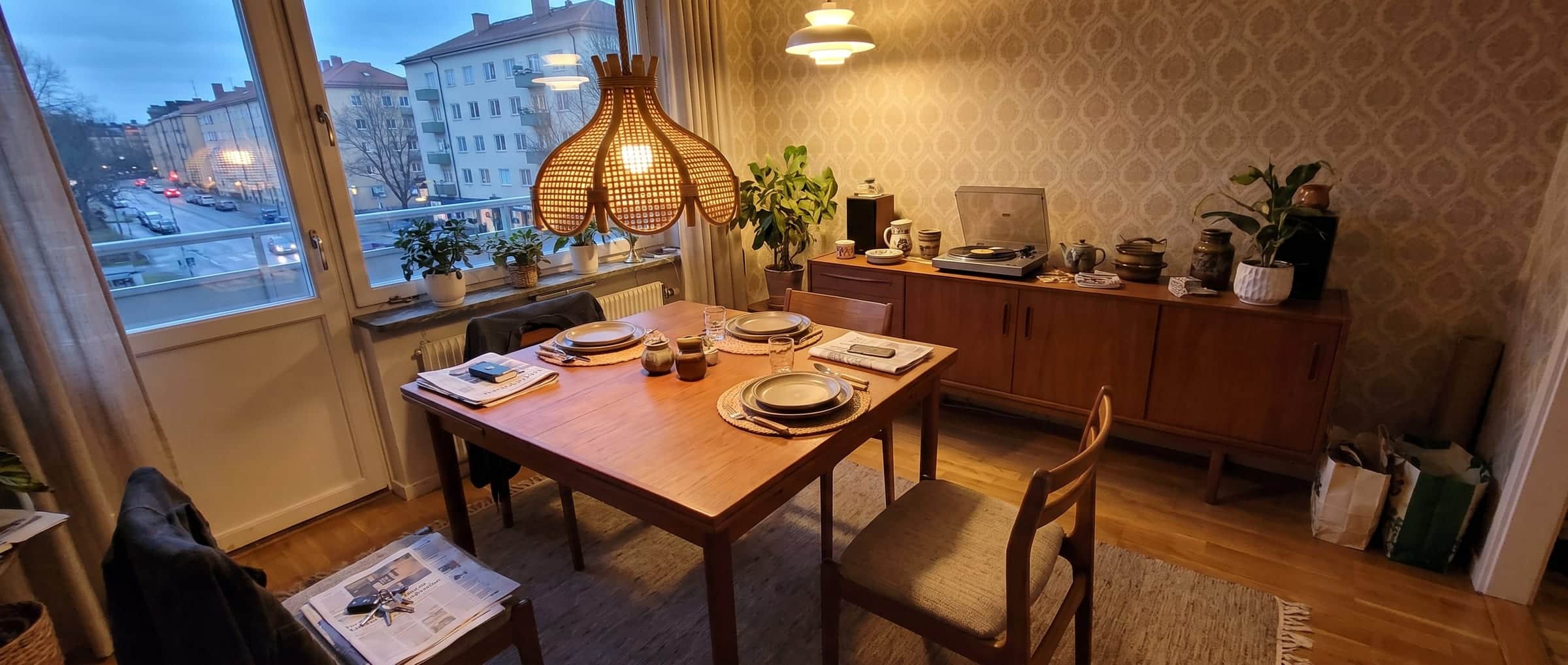 Ratanový lustr nad prostřeným stolem za soumraku